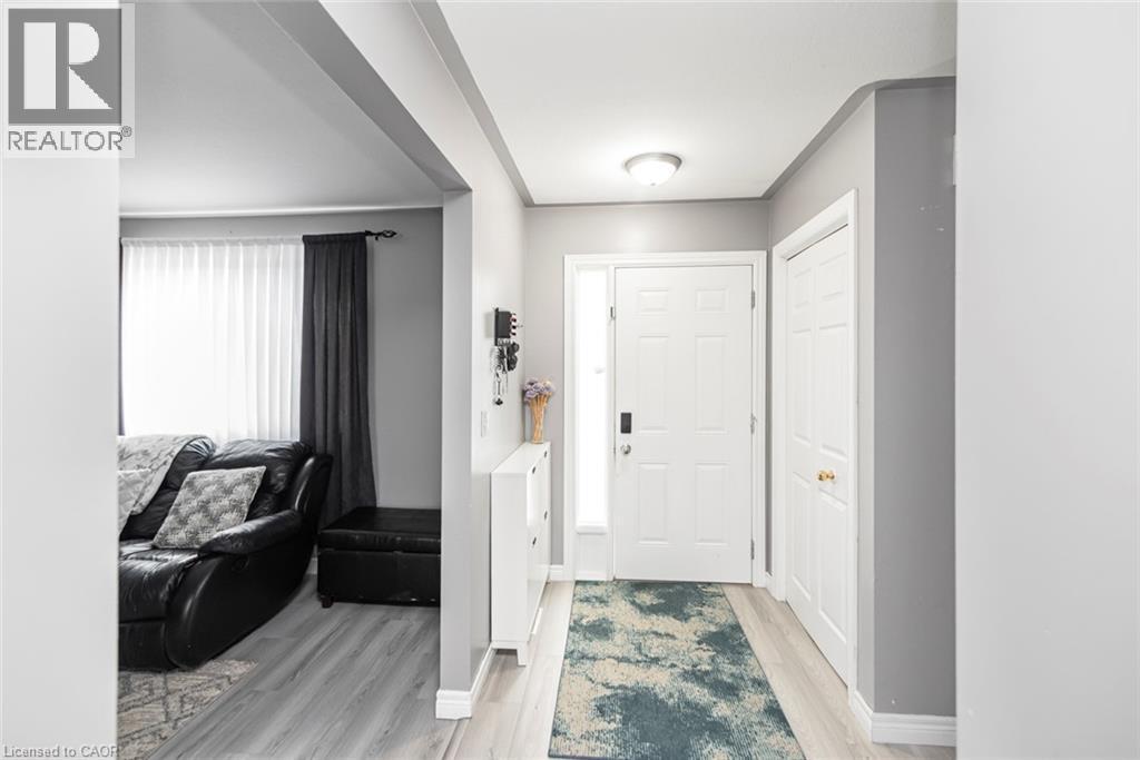 Recessed ceiling lighting, wood-finish flooring, white paneled doors, and a decorative frosted glass sidelight - 42 Saturn Road, Port Colborne, ON