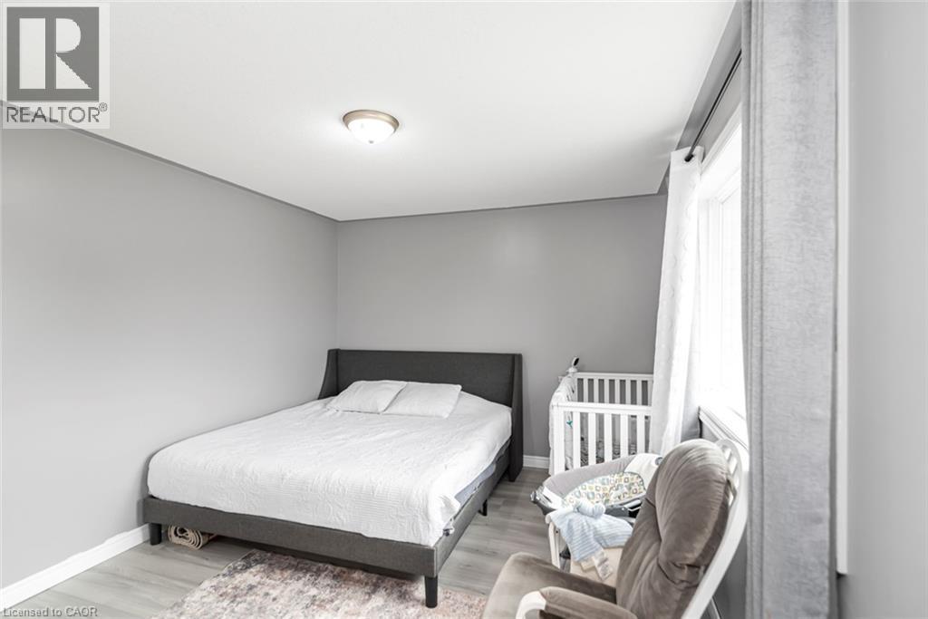 Recessed ceiling light fixture, neutral gray wall paint, light-toned wood-finish flooring, and white window trim - 42 Saturn Road, Port Colborne, ON