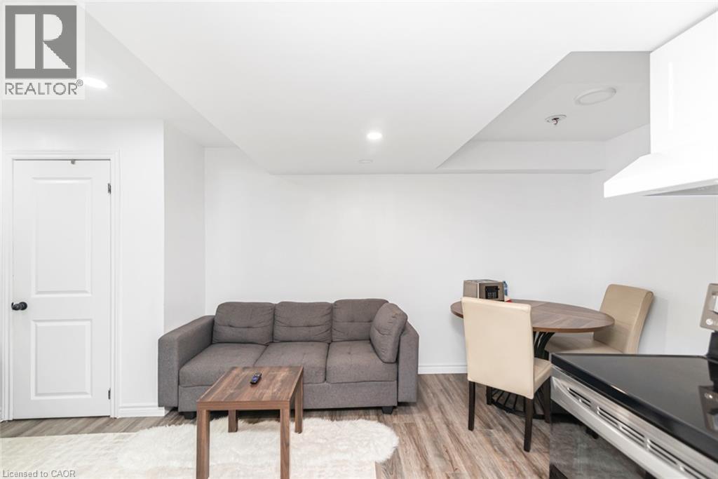 Recessed lighting, wood-finish flooring, white paneled door, and built-in range hood - 42 Saturn Road, Port Colborne, ON