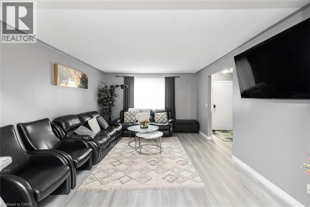 Light gray wall paint, light wood-finish flooring, white ceiling, window with dark drapes, recessed lighting - 42 Saturn Road, Port Colborne, ON