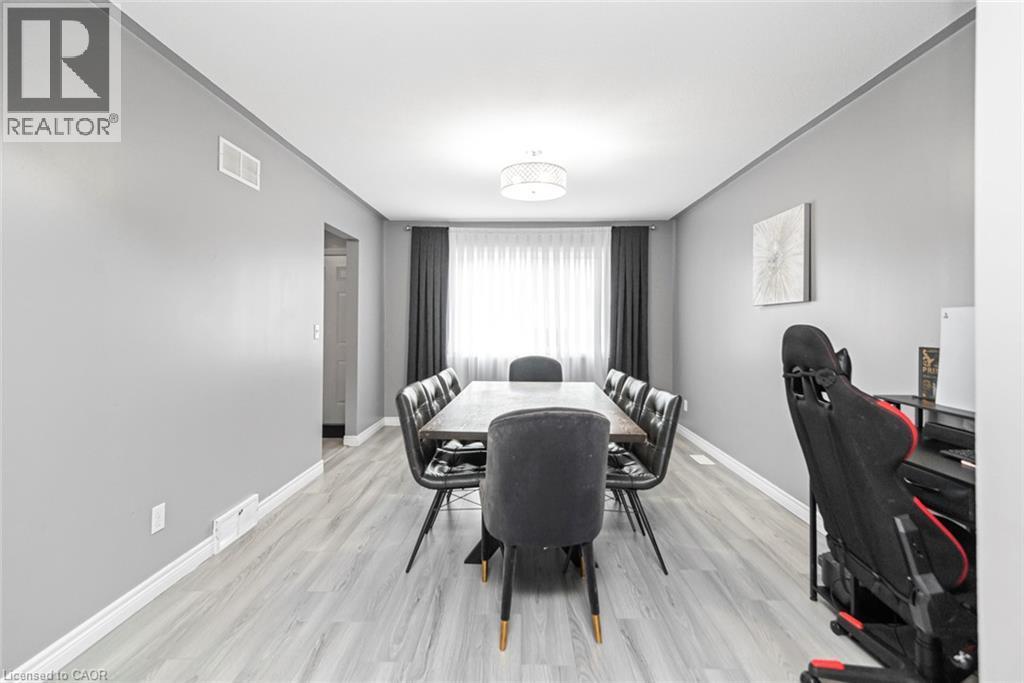Recessed lighting and a decorative ceiling fixture illuminate this space, featuring wood-finish flooring and light gray painted walls - 42 Saturn Road, Port Colborne, ON