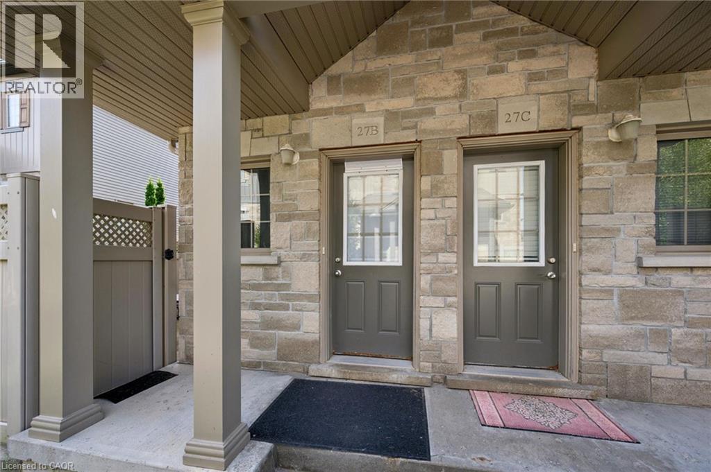 Stone veneer facade, covered porch with pillars, two entry doors with glass inserts, exterior wall sconces, and a side gate - 931 Glasgow Street Unit# 27B, Kitchener, ON