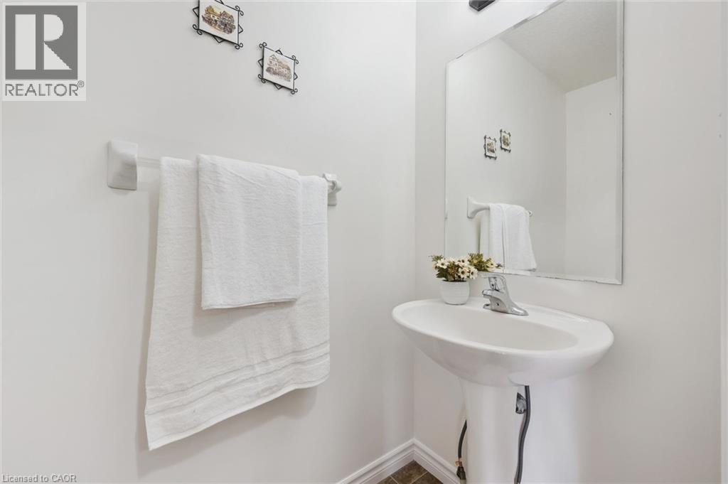 Pedestal sink with a chrome faucet, wall-mounted mirror, and tile flooring - 931 Glasgow Street Unit# 27B, Kitchener, ON
