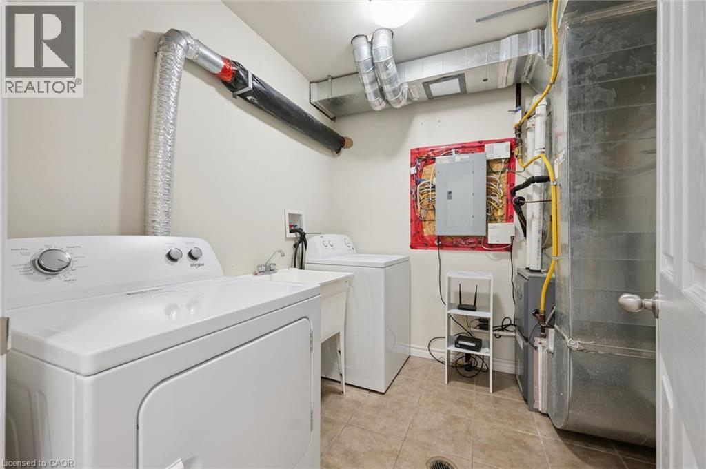 Utility area featuring a laundry sink, electrical panel, and tiled flooring - 931 Glasgow Street Unit# 27B, Kitchener, ON