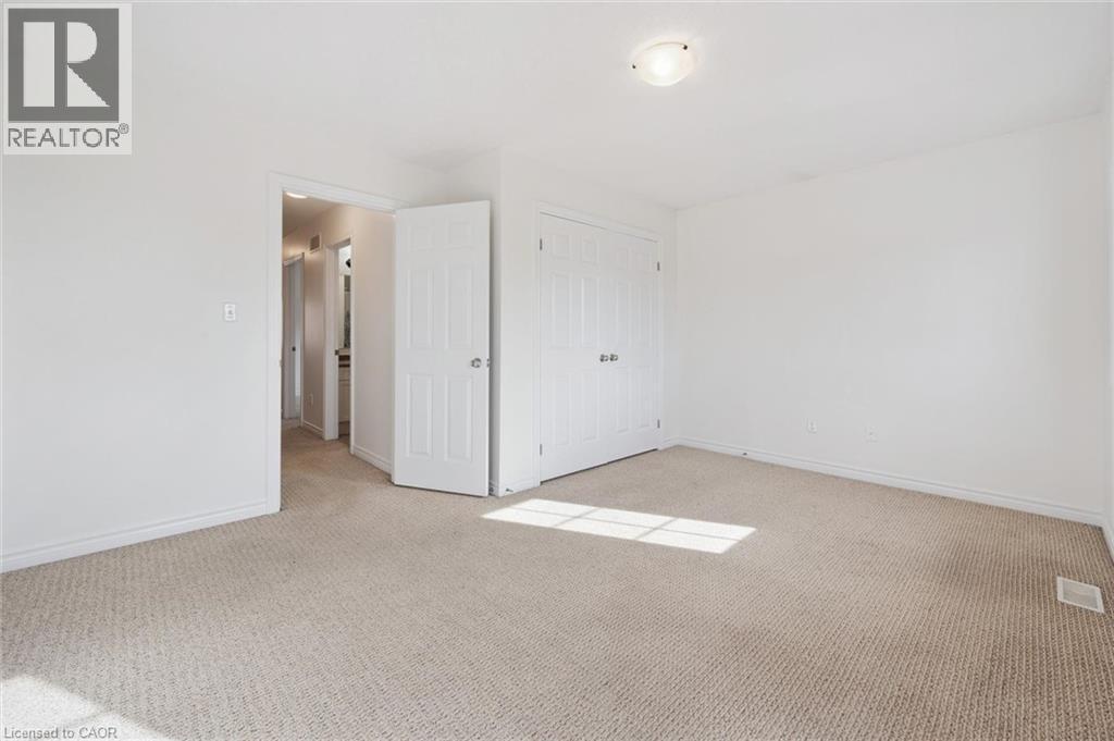 Neutral tone carpeting, white painted walls, and ceiling-mounted light fixture - 931 Glasgow Street Unit# 27B, Kitchener, ON