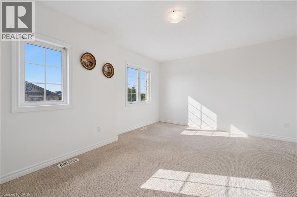 Neutral wall paint, light-toned carpeting, multiple pane windows, and a ceiling-mounted light fixture - 931 Glasgow Street Unit# 27B, Kitchener, ON
