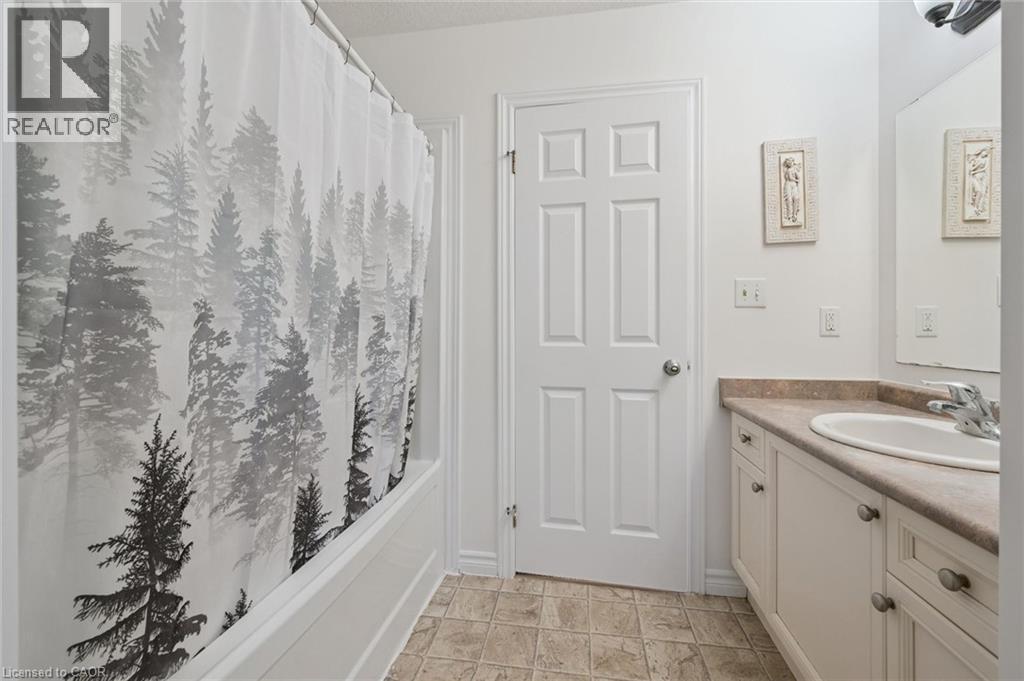 White panel door, built-in vanity with light-toned countertop, integrated sink, and undermount cabinetry - 931 Glasgow Street Unit# 27B, Kitchener, ON