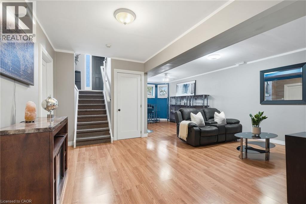 Wood-finish flooring, recessed lighting, white interior doors, and a carpeted staircase - 94 Kent Road, Brantford, ON