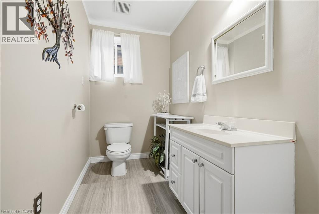 White vanity with dual cabinet doors and an integrated sink - 94 Kent Road, Brantford, ON