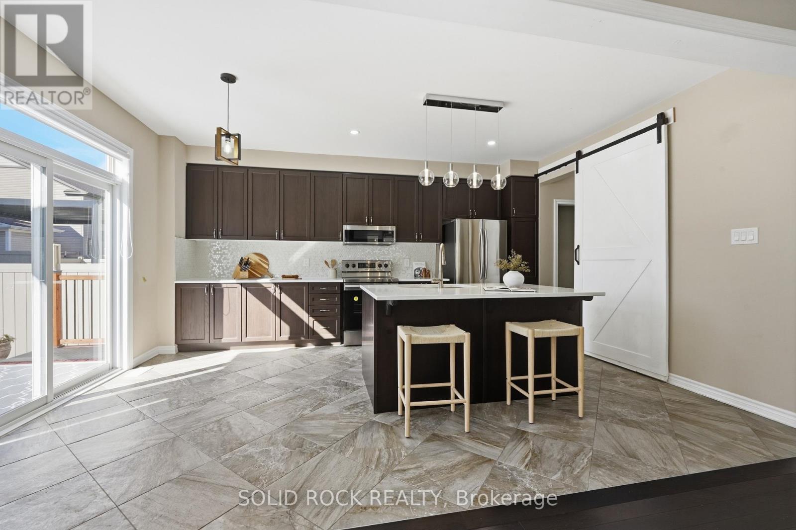 Spacious kitchen with a stylish barn door - 55 Solaris Drive, Ottawa, ON