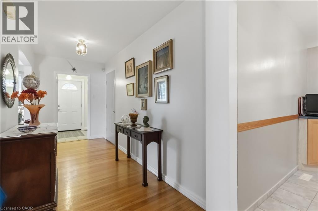 Hardwood flooring extending throughout the hallway, bright white walls, and a recessed ceiling light fixture - 152 Hilda Avenue, North York, ON