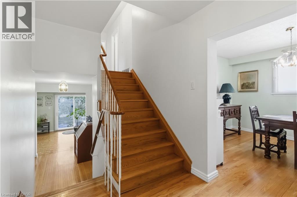 Hardwood flooring, wood staircase with white balusters, and a sliding glass door - 152 Hilda Avenue, North York, ON