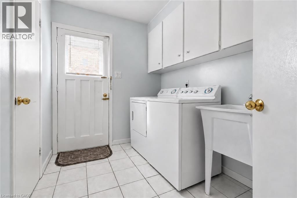 White tile flooring, utility sink, white upper cabinetry, and white appliances - 152 Hilda Avenue, North York, ON