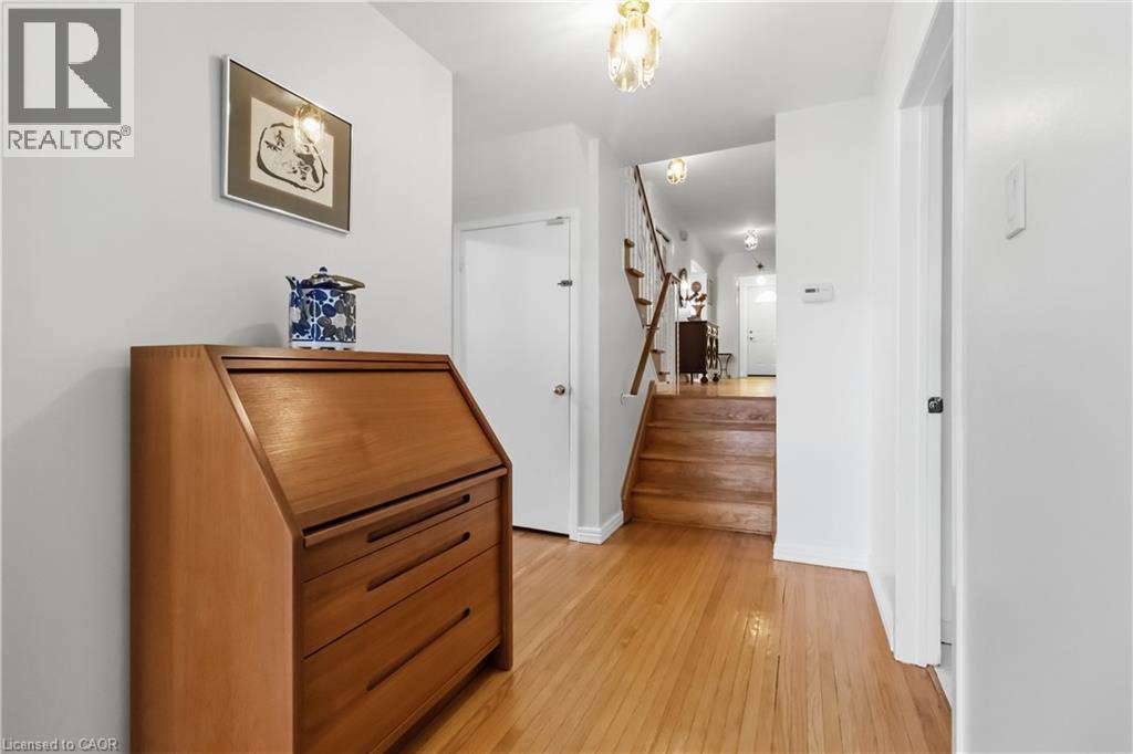 Hardwood flooring, painted white walls, wood staircase with white risers, and decorative flush-mount lighting fixtures - 152 Hilda Avenue, North York, ON