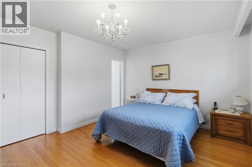 Polished wood-finish flooring, white walls, bi-fold closet doors, and a crystal chandelier - 152 Hilda Avenue, North York, ON