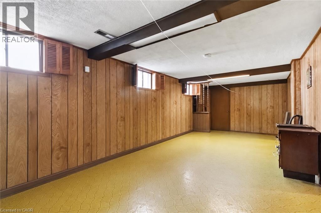 Room featuring wood-paneled walls, multiple windows, and a built-in recessed cabinet - 152 Hilda Avenue, North York, ON