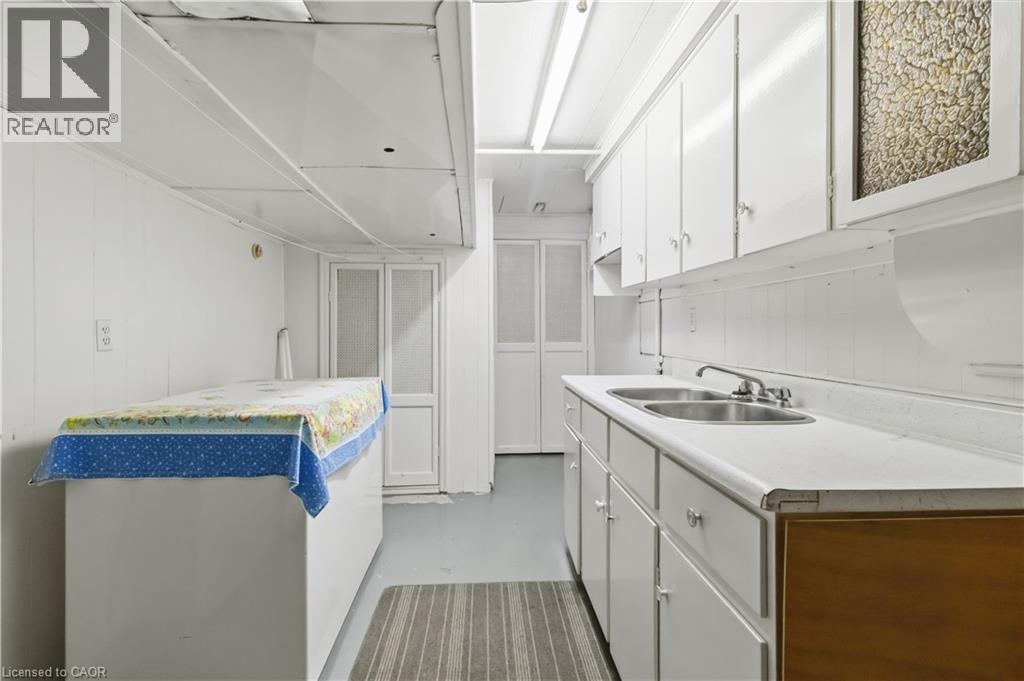 White cabinetry with ample storage, dual basin sink, integrated countertop, and paneling - 152 Hilda Avenue, North York, ON