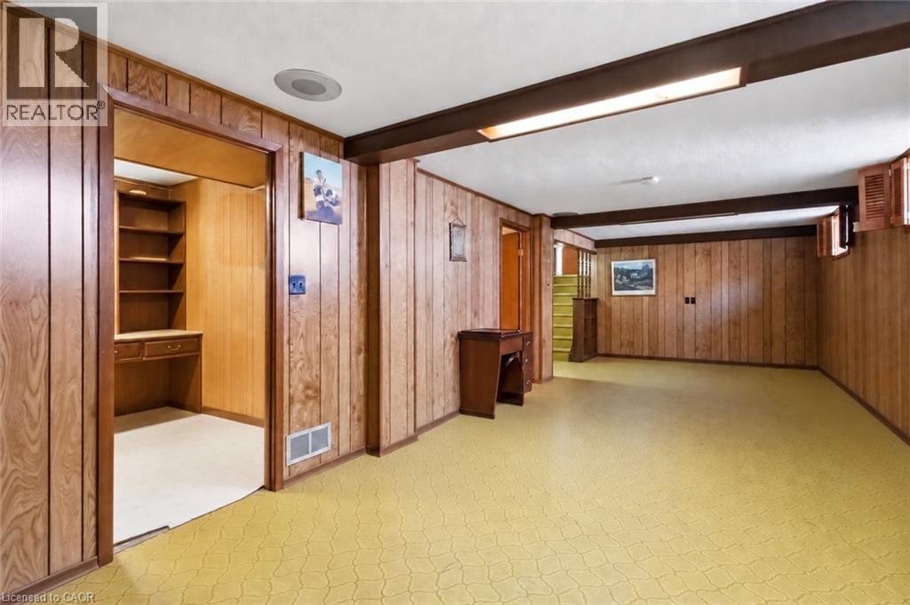Spacious room featuring wood paneling, recessed lighting, exposed ceiling beams, and a built-in desk with shelving - 152 Hilda Avenue, North York, ON