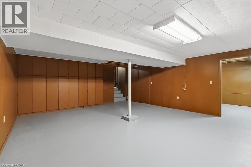 Spacious lower level featuring built-in storage cabinetry, painted concrete flooring, and a drop ceiling with fluorescent lighting - 152 Hilda Avenue, North York, ON