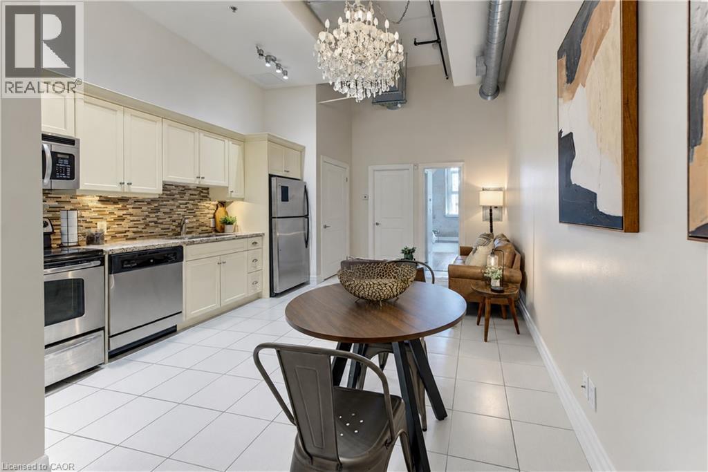 Open-concept living space with a kitchen featuring stainless steel appliances, light-toned cabinetry, and a mosaic tile backsplash - 25 Concession Street Unit# 110, Cambridge, ON
