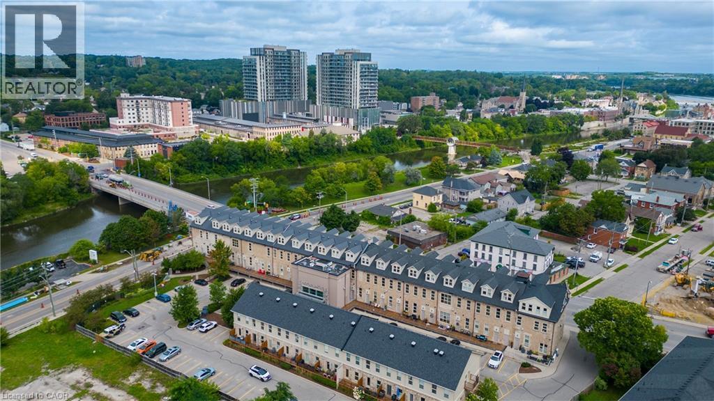 Aerial perspective showcasing urban residential buildings, proximity to a river, and surrounding green spaces - 25 Concession Street Unit# 110, Cambridge, ON