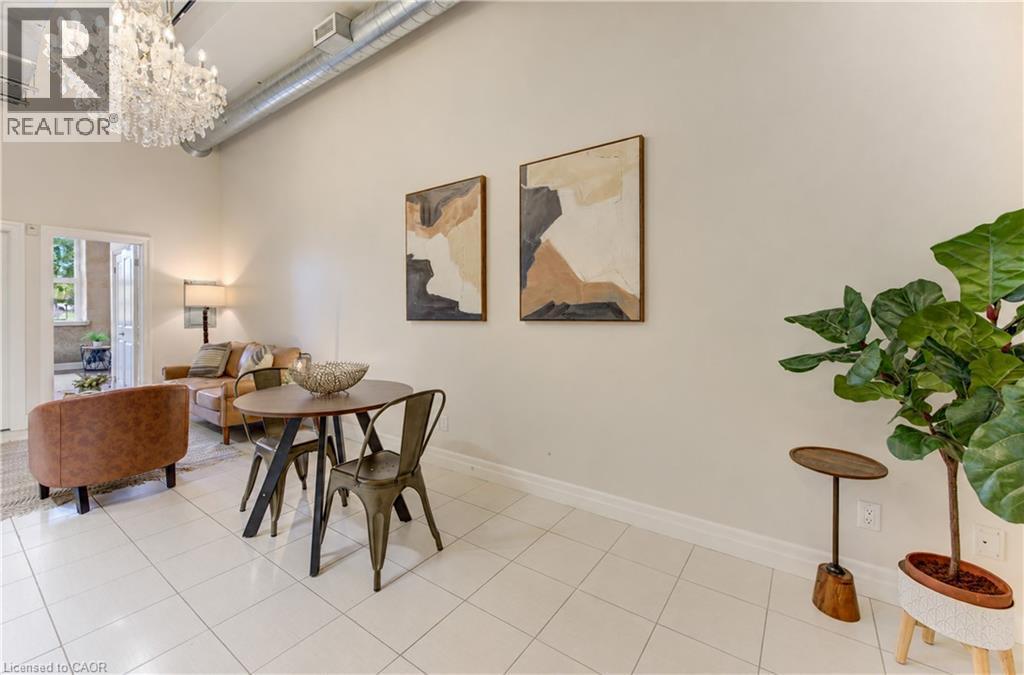 High ceilings with exposed ductwork, tile flooring, and French doors leading to an outdoor space - 25 Concession Street Unit# 110, Cambridge, ON
