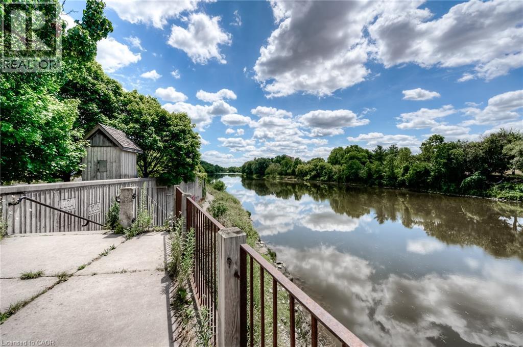 Riverside property featuring a rustic outbuilding and mature trees - 25 Concession Street Unit# 110, Cambridge, ON