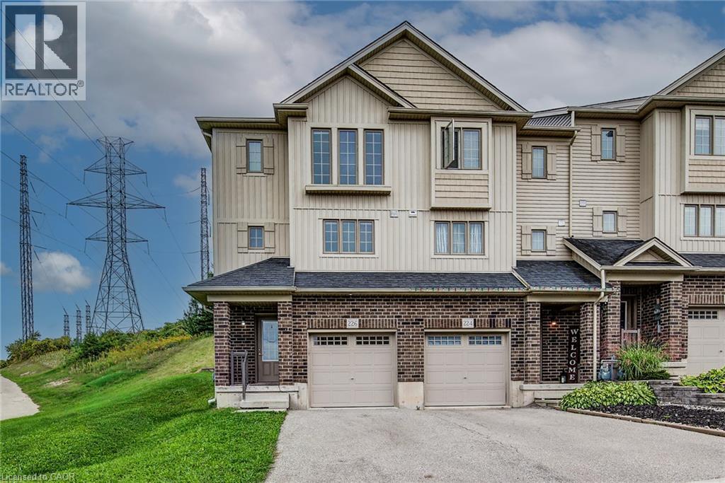 Multi-level townhouse exterior featuring brick and siding facade, covered front entry, and attached garage - 226 Maitland Street, Kitchener, ON