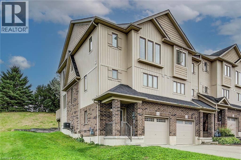 Multi-level townhouse with brick and siding exterior, private garage, and sloped grassy area - 226 Maitland Street, Kitchener, ON