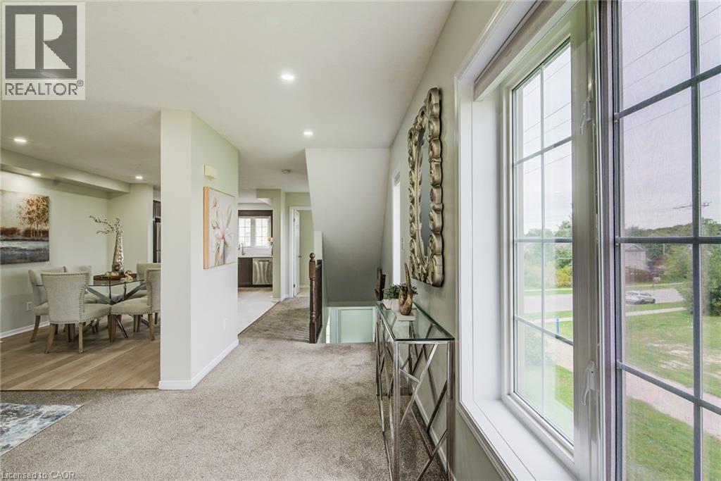 Recessed lighting, light-toned walls, wood-finish flooring, and carpeted hallway with a window - 226 Maitland Street, Kitchener, ON