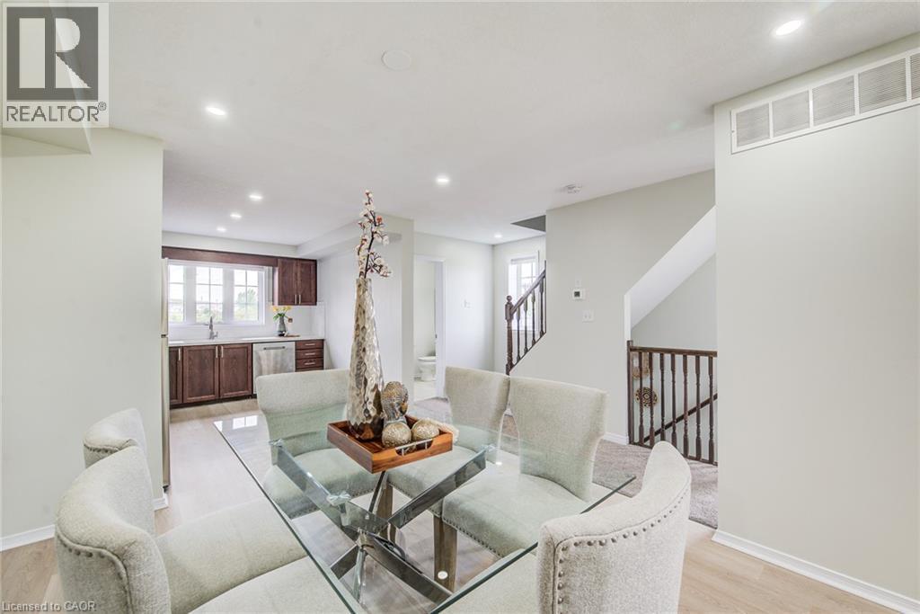 Recessed lighting, light wood-finish flooring, dark wood cabinetry, stainless steel appliances, and a wood railing staircase - 226 Maitland Street, Kitchener, ON