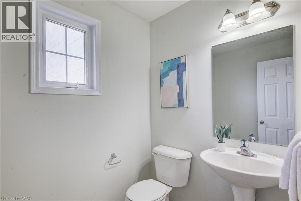 Pedestal sink, wall-mounted rectangular mirror, and two-light vanity fixture - 226 Maitland Street, Kitchener, ON