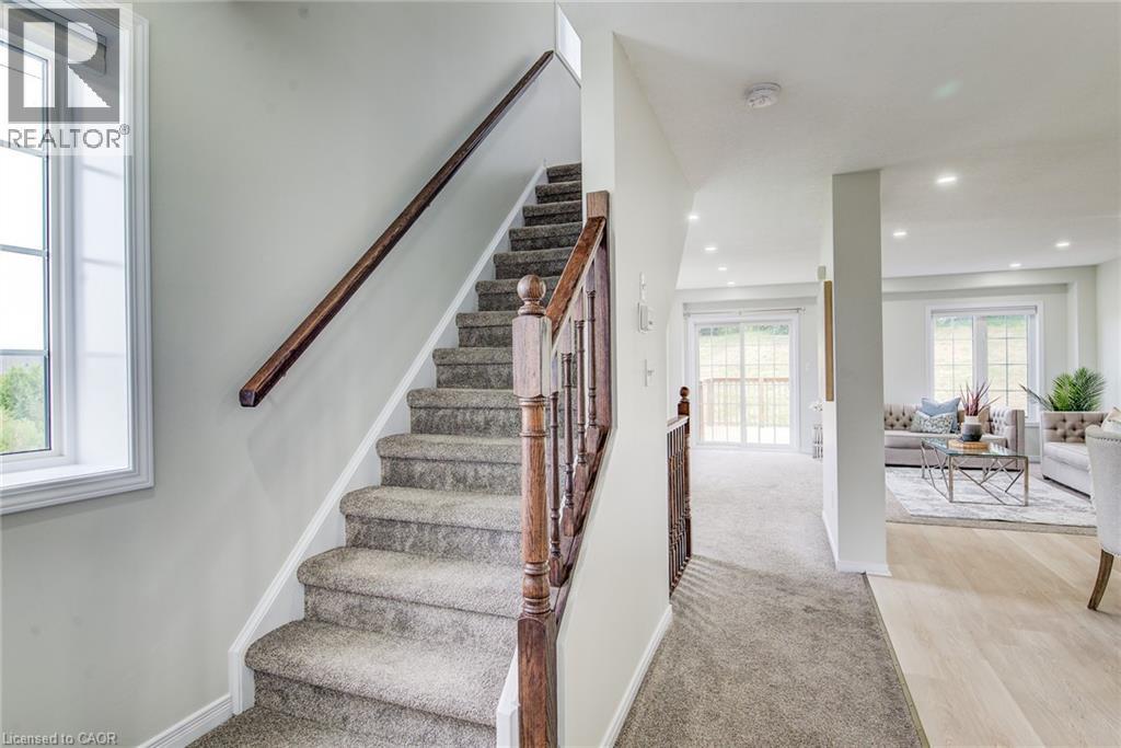 Carpeted staircase with wood handrail, recessed lighting, and light wood-finish flooring - 226 Maitland Street, Kitchener, ON