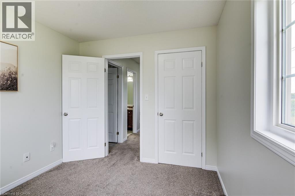 Window with white trim, light-toned carpeting, and a six-panel door - 226 Maitland Street, Kitchener, ON