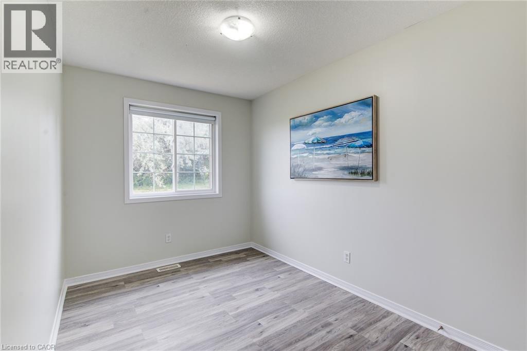 Light gray wall paint, wood-finish flooring, white window trim, and a flush mount ceiling light - 226 Maitland Street, Kitchener, ON