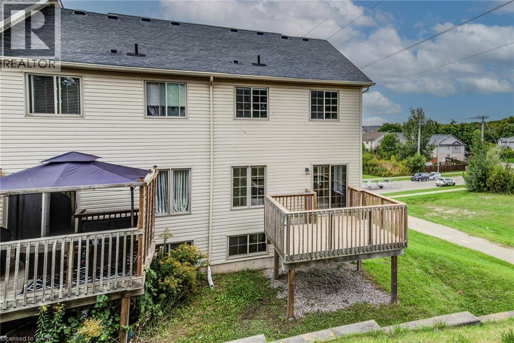 Rear elevation with light-colored siding, multiple windows, a dark shingled roof, and an elevated wood deck - 226 Maitland Street, Kitchener, ON