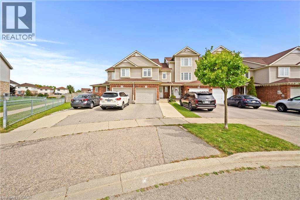 Siding exterior with brick accents, two-car garage, and paved driveway - 245 Red Clover Court, Kitchener, ON