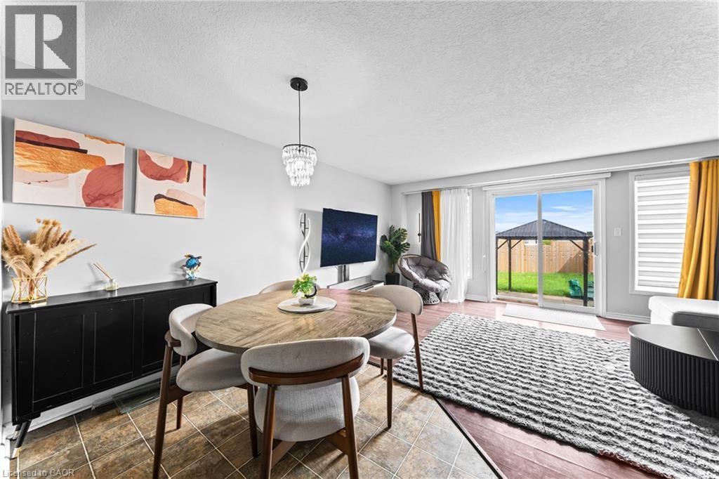 Hardwood flooring, sliding glass door, modern chandelier, tile flooring, and window blinds - 245 Red Clover Court, Kitchener, ON