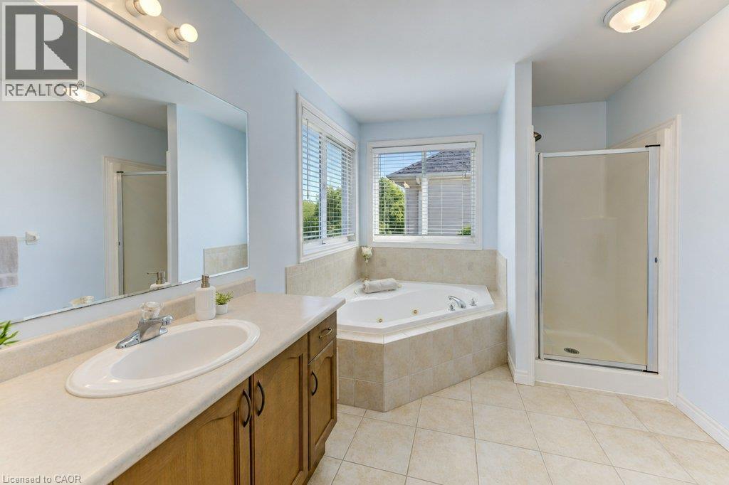 Double vanity with integrated sink, chrome faucet, and wood-finish cabinetry - 88 Decaro Crescent, Cambridge, ON
