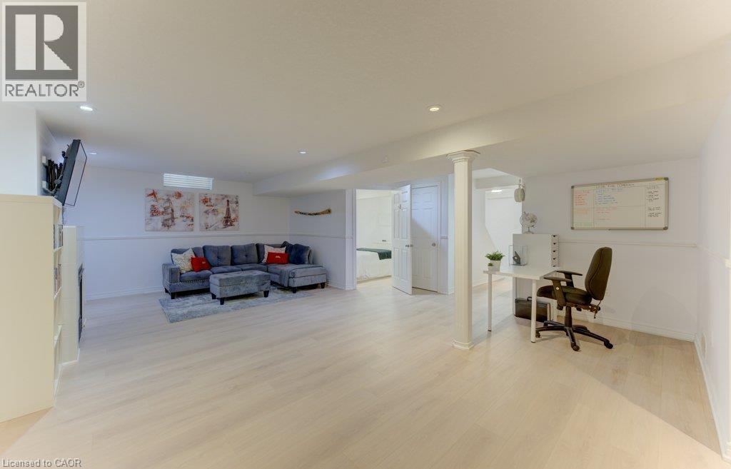 Spacious room featuring light wood-finish flooring, recessed lighting, and white paneled walls - 88 Decaro Crescent, Cambridge, ON