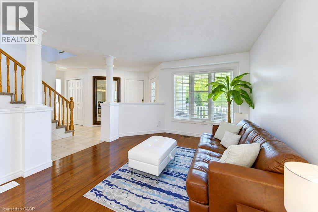 Hardwood flooring, bay window with blinds, tile flooring, balustrade staircase, and architectural columns - 88 Decaro Crescent, Cambridge, ON