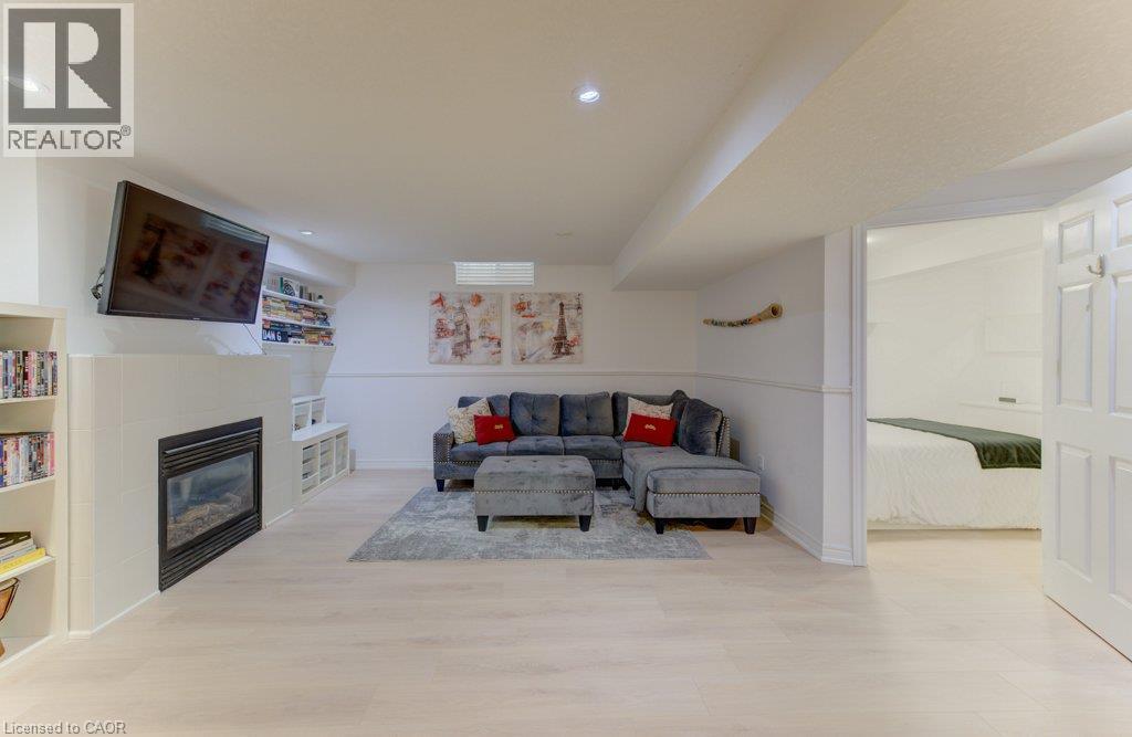 Recessed lighting, wood-finish flooring, and a built-in fireplace - 88 Decaro Crescent, Cambridge, ON