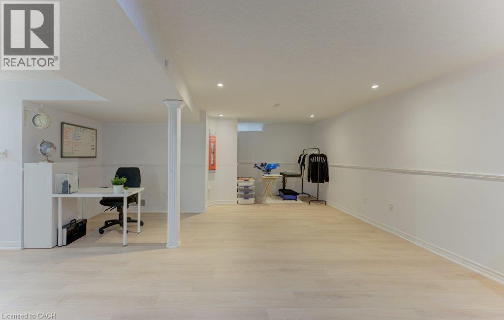 Recessed lighting illuminating the large open-concept space featuring wood-finish flooring and wainscoting - 88 Decaro Crescent, Cambridge, ON