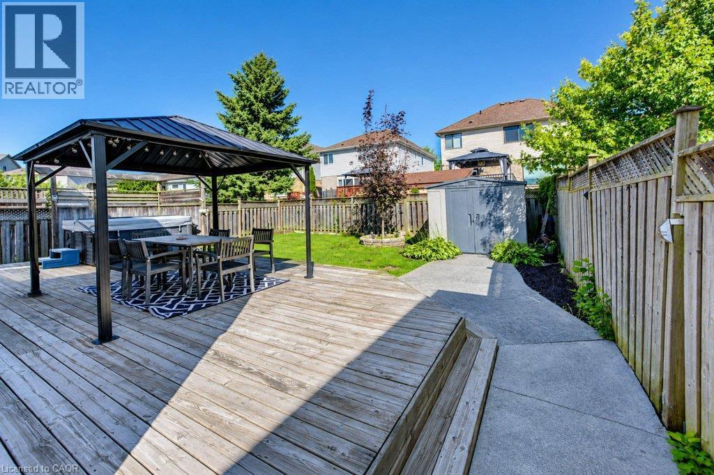 Large wood deck with built-in steps, covered gazebo, hot tub, concrete pathway, and storage shed - 88 Decaro Crescent, Cambridge, ON