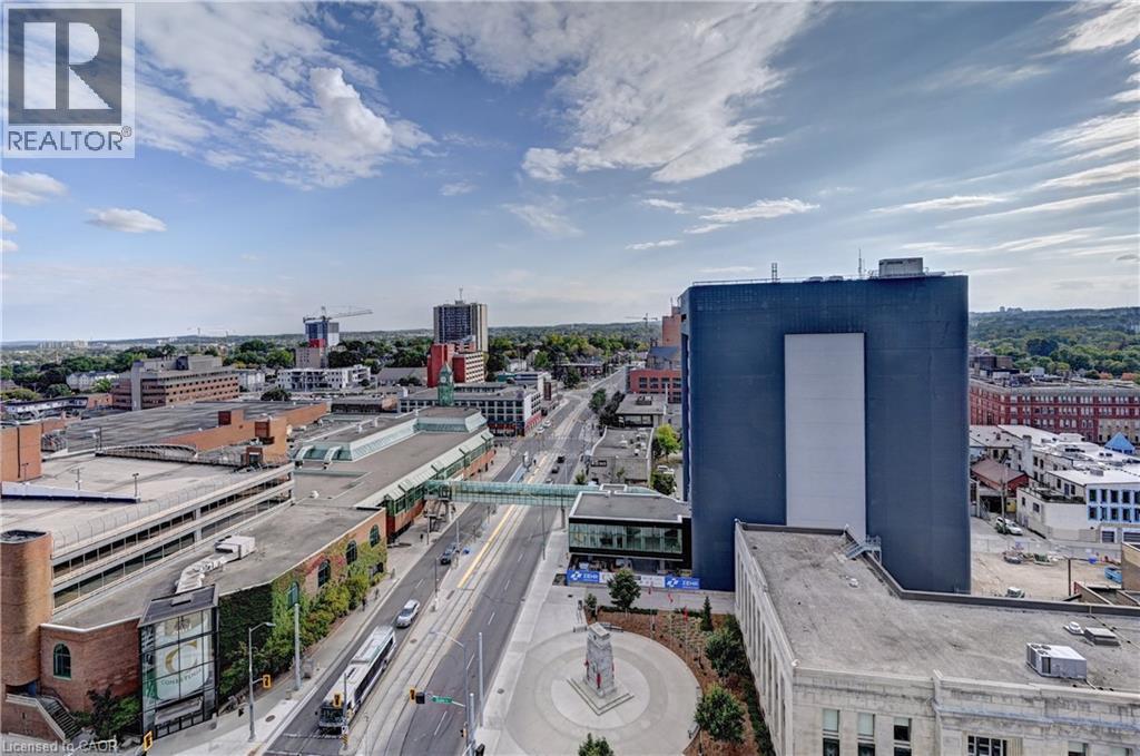 Urban landscape featuring multiple high-rise buildings, a multi-story parking structure, and a central thoroughfare - 60 Frederick Street Unit# 1213, Kitchener, ON