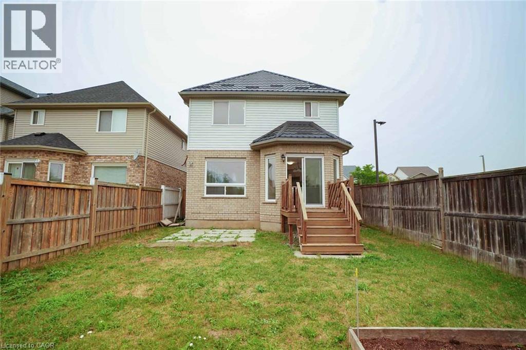 Rear exterior featuring a wood deck, sliding glass door, and bay window - 18 Heritage Drive, Guelph, ON