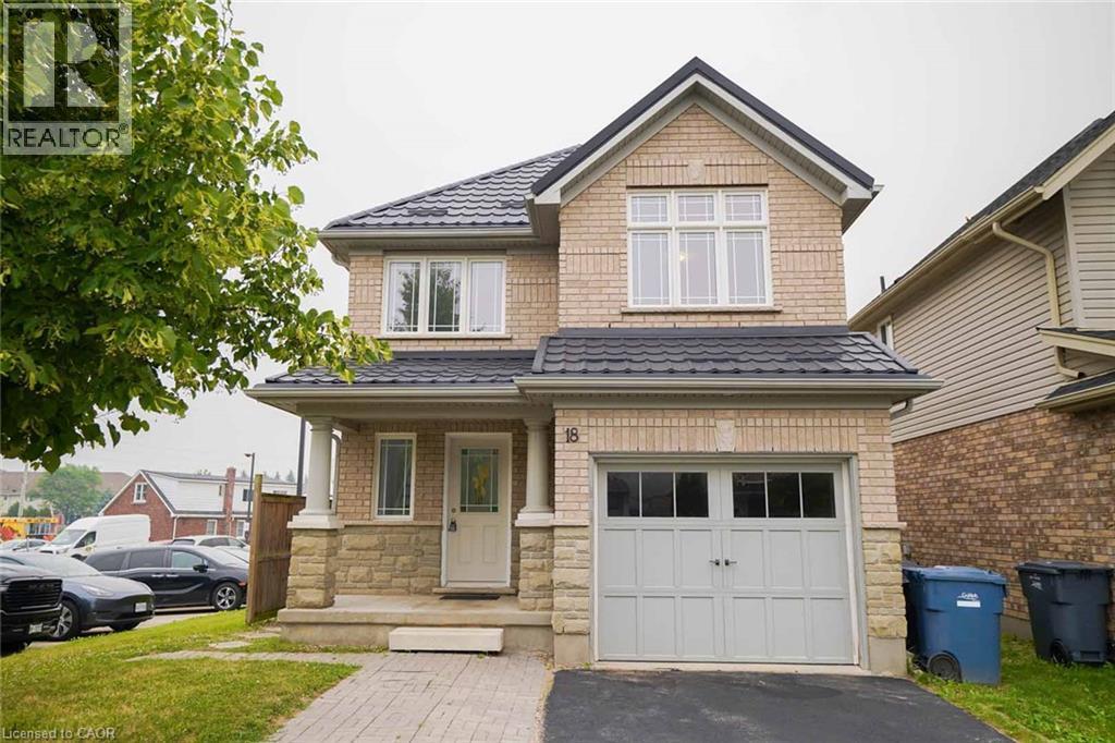 Brick exterior with stone accents, covered front porch, integrated garage, and a dark tile roof - 18 Heritage Drive, Guelph, ON