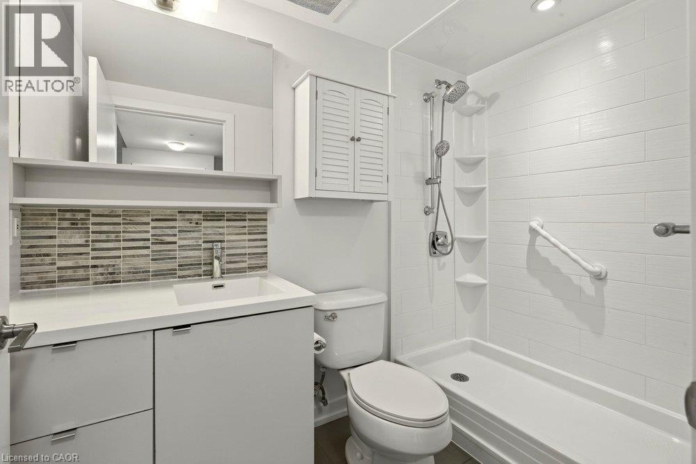 Modern bathroom featuring a walk-in shower with white subway tile, an integrated shower system, and built-in shelving - 457 Plains Road Unit# 225, Burlington, ON