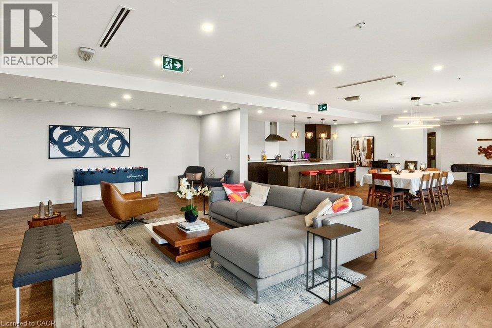 Open-concept living space featuring wood-finish flooring, recessed lighting, and a modern kitchen with an island and pendant lights - 457 Plains Road Unit# 225, Burlington, ON