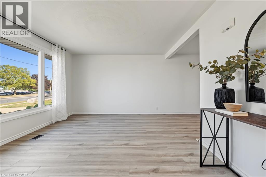 BRIGHT & INVITING living room with massive vinyl window adds natural light to this lovely open floor plan. - 589 Mohawk Road W, Hamilton, ON